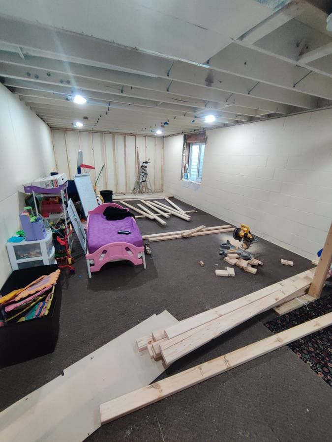 picture of a newly remodeled basement with custom lights, new windows, floors, and walls