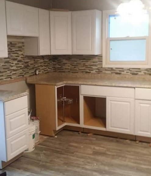 picture of a luxury kitchen in the process of being remodeled with newly installed windows, cabinets, and custom backsplash